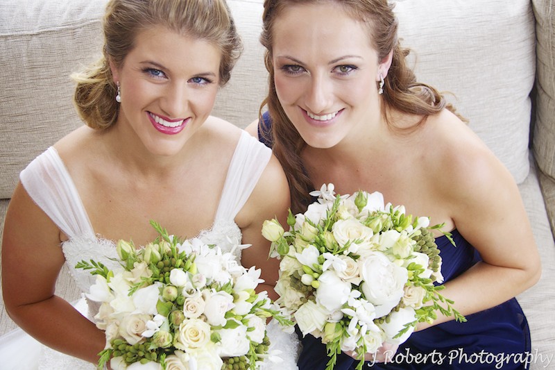 Bride and bridesmaid in blue smiling up at the camera - wedding photography sydney